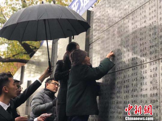 夏淑琴老人用手撫摸著親人的名字?！≈鞎苑f 攝