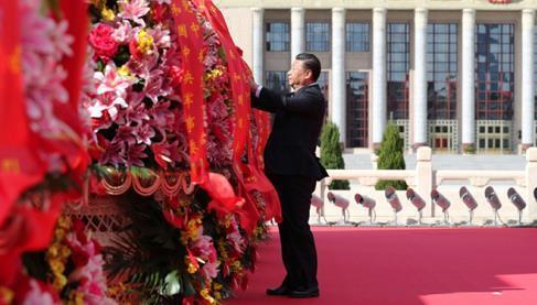 9月30日上午，習(xí)近平等黨和國家領(lǐng)導(dǎo)人來到北京天安門廣場，出席烈士紀(jì)念日向人民英雄敬獻(xiàn)花籃儀式。這是習(xí)近平整理花籃上的緞帶。圖片來源：新華社